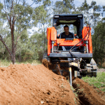 trencher on skid steer digging trench