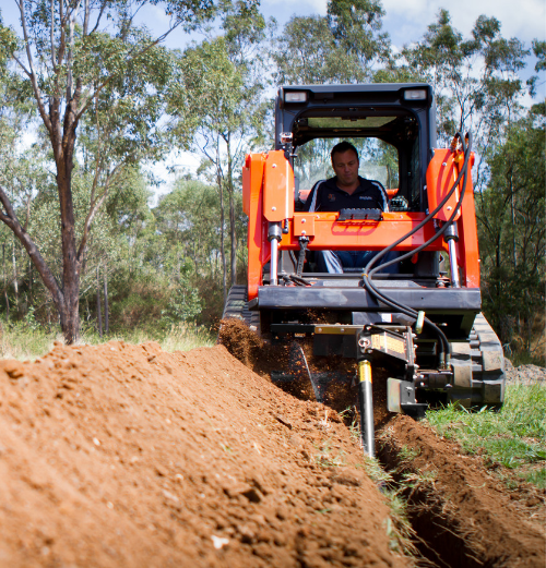 trencher on skid steer digging trench